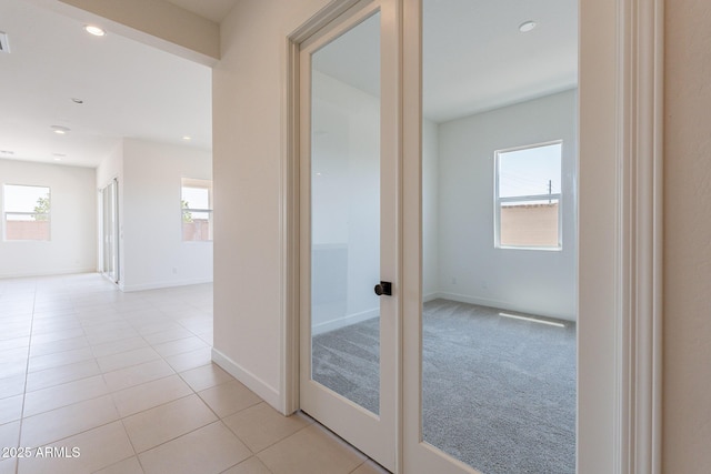 hall featuring light colored carpet, light tile patterned floors, recessed lighting, and baseboards