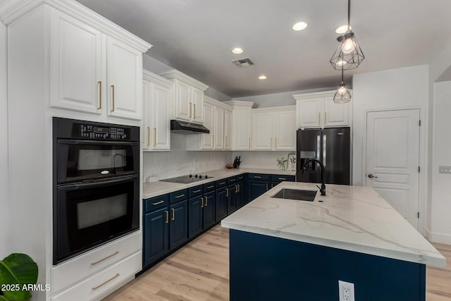 465 E Frances Ln, Gilbert, AZ 85295 - kitchen featuring black appliances, blue cabinets, light wood-style floors, a kitchen island with sink, and tasteful backsplash