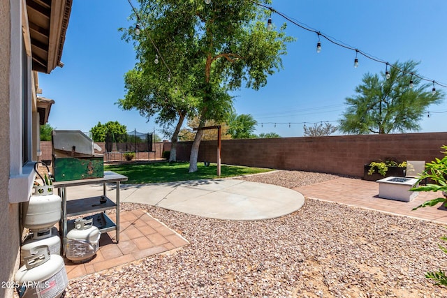 465 E Frances Ln, Gilbert, AZ 85295 - fenced backyard with a trampoline, a patio area, and an outdoor fire pit