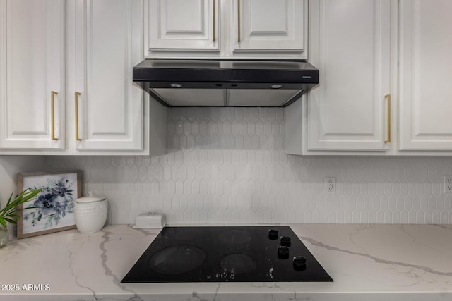 465 E Frances Ln, Gilbert, AZ 85295 - kitchen with black electric stovetop, under cabinet range hood, white cabinetry, decorative backsplash, and light stone counters