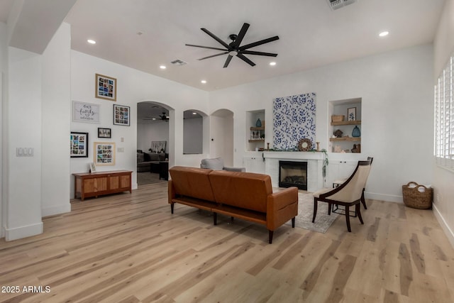 465 E Frances Ln, Gilbert, AZ 85295 - living area featuring ceiling fan, light wood finished floors, a fireplace, arched walkways, and recessed lighting