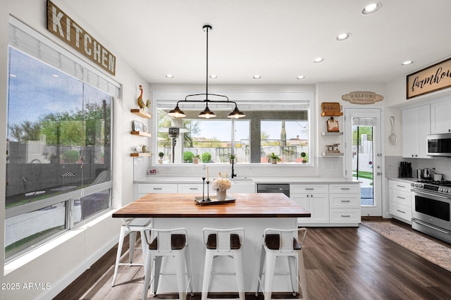 kitchen with wooden counters, white cabinetry, open shelves, and appliances with stainless steel finishes