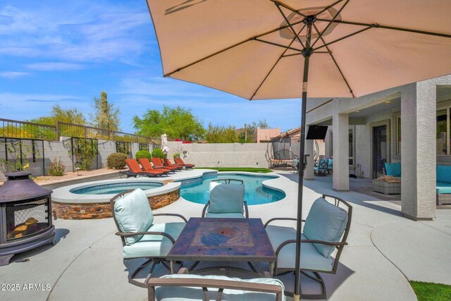 view of swimming pool with a fenced backyard, outdoor dining area, a patio, and a trampoline