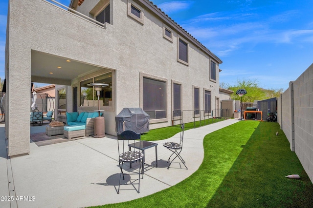 back of property with a fenced backyard, a lawn, stucco siding, and a patio area