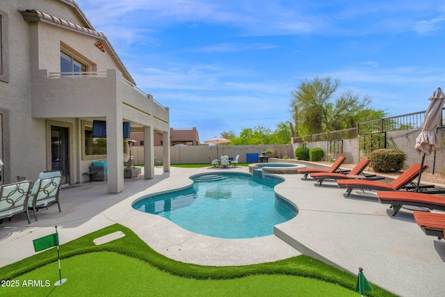 view of swimming pool featuring a fenced backyard, a pool with connected hot tub, and a patio area
