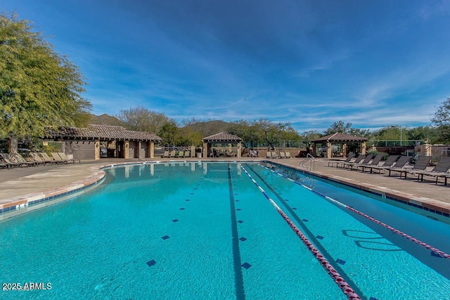 community pool with a patio, fence, and a gazebo
