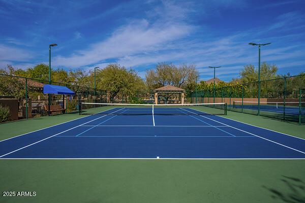 view of tennis court featuring fence