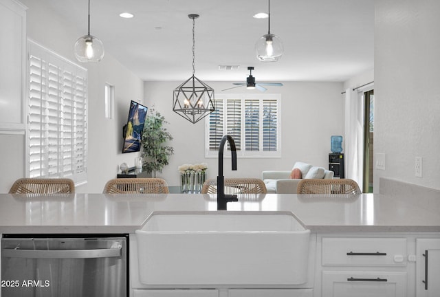 kitchen with hanging light fixtures, dishwasher, sink, and white cabinets