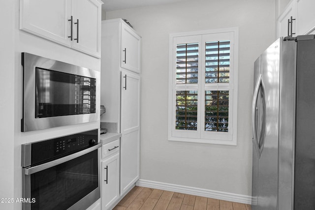 kitchen with appliances with stainless steel finishes and white cabinets