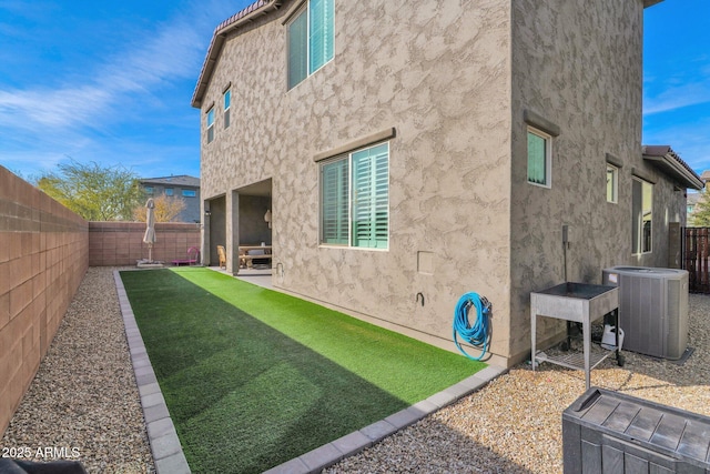 rear view of house featuring a yard, central AC, and a patio area