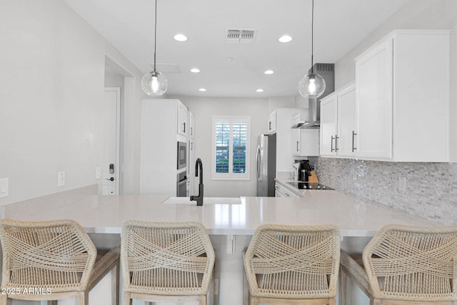 kitchen featuring sink, stainless steel appliances, a breakfast bar, and kitchen peninsula