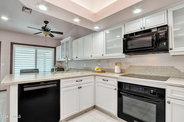 kitchen with sink, white cabinetry, black appliances, light stone countertops, and kitchen peninsula