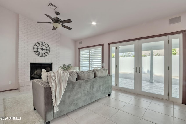 tiled living room featuring french doors, ceiling fan, lofted ceiling, and a fireplace