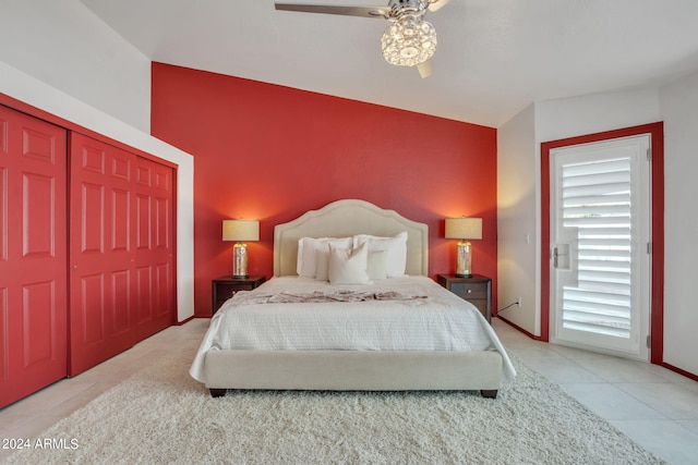 bedroom featuring ceiling fan, vaulted ceiling, a closet, and light tile patterned floors