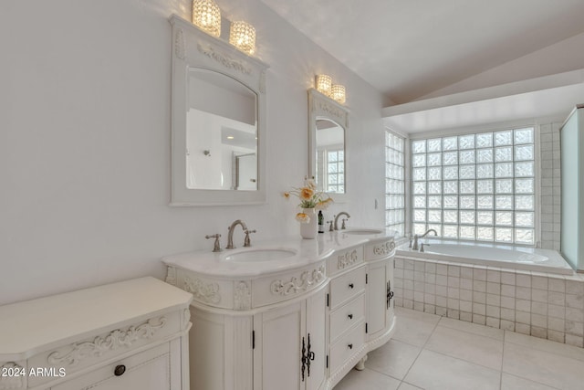 bathroom with vaulted ceiling, tiled bath, tile patterned floors, and vanity