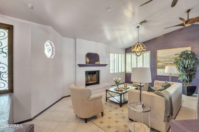 living room with lofted ceiling, ceiling fan with notable chandelier, and a fireplace