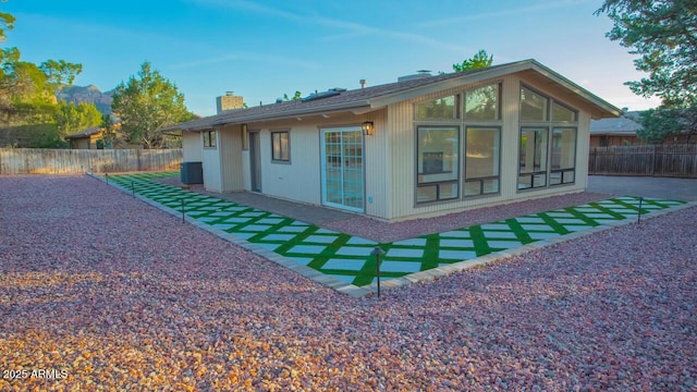21 Hummingbird Cir, Sedona, AZ 86336 - rear view of property with a chimney, a fenced backyard, central AC unit, and a sunroom