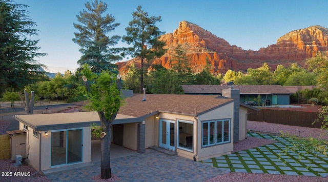21 Hummingbird Cir, Sedona, AZ 86336 - back of property featuring a patio area, a mountain view, and a chimney