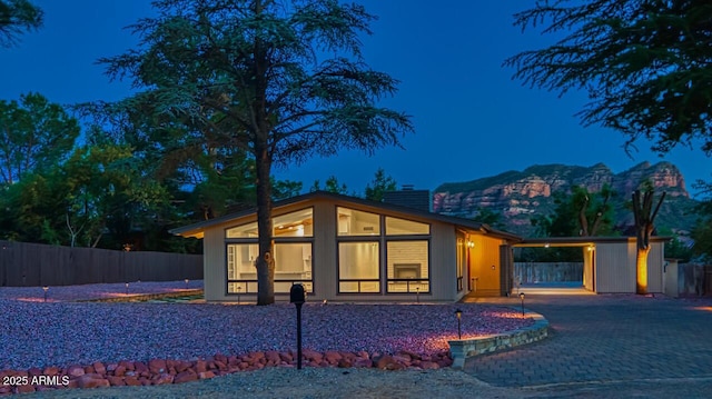 21 Hummingbird Cir, Sedona, AZ 86336 - contemporary house featuring a chimney, a mountain view, an attached carport, driveway, and a sunroom