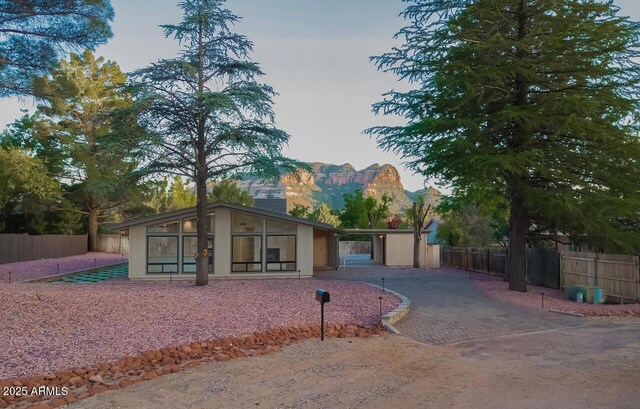 21 Hummingbird Cir, Sedona, AZ 86336 - mid-century inspired home with decorative driveway, stucco siding, a sunroom, and a carport