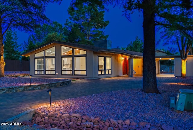 21 Hummingbird Cir, Sedona, AZ 86336 - back of house at twilight with a chimney and a patio