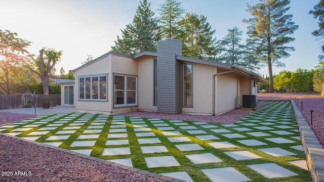 21 Hummingbird Cir, Sedona, AZ 86336 - back of house featuring a chimney, central AC unit, and a patio