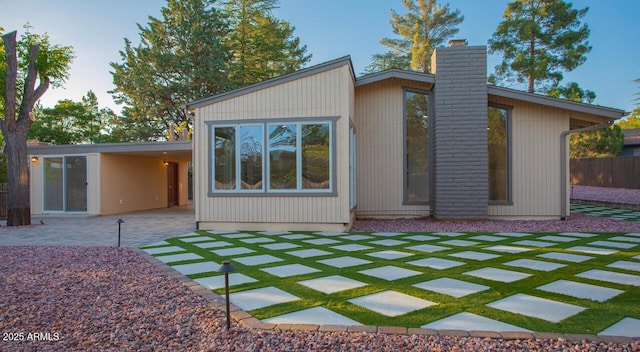 21 Hummingbird Cir, Sedona, AZ 86336 - back of house featuring a chimney and a patio