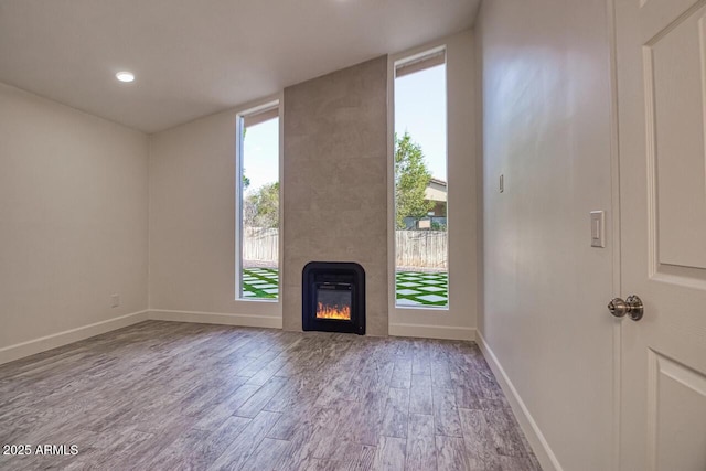 21 Hummingbird Cir, Sedona, AZ 86336 - unfurnished living room with wood finished floors, a large fireplace, baseboards, and recessed lighting