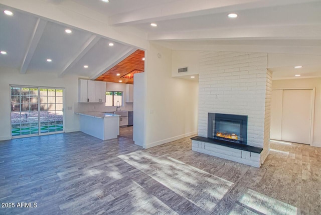 21 Hummingbird Cir, Sedona, AZ 86336 - unfurnished living room featuring wood finished floors, a brick fireplace, baseboards, a sink, and recessed lighting