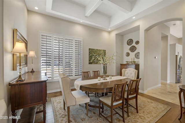 dining room with beamed ceiling and light wood-type flooring