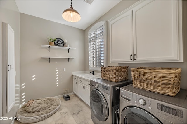 washroom featuring cabinets, washer and clothes dryer, and sink