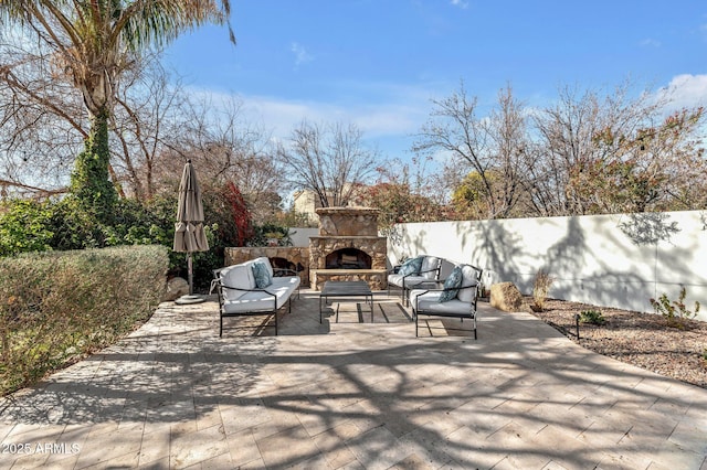 view of patio with an outdoor living space with a fireplace