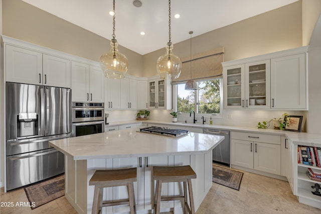 kitchen with a kitchen island, white cabinetry, appliances with stainless steel finishes, and hanging light fixtures