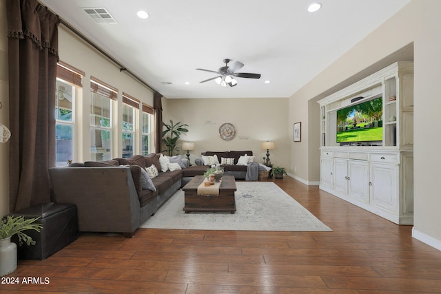 living room featuring ceiling fan and dark wood-type flooring