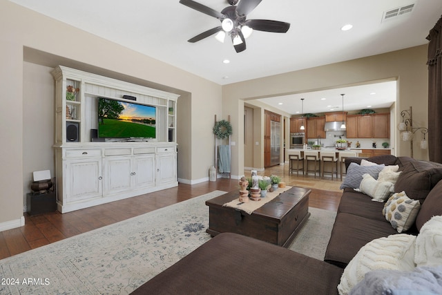 living room with dark hardwood / wood-style floors and ceiling fan