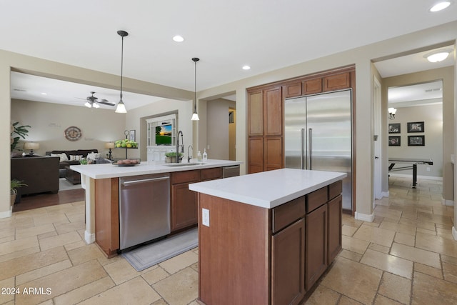 kitchen with ceiling fan, a center island, sink, decorative light fixtures, and dishwasher