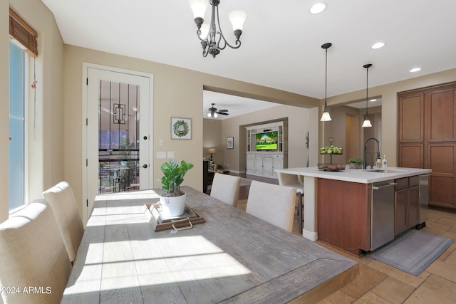 dining space featuring ceiling fan with notable chandelier and sink