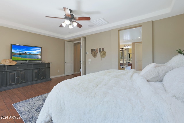 bedroom with ceiling fan, a raised ceiling, and dark hardwood / wood-style flooring