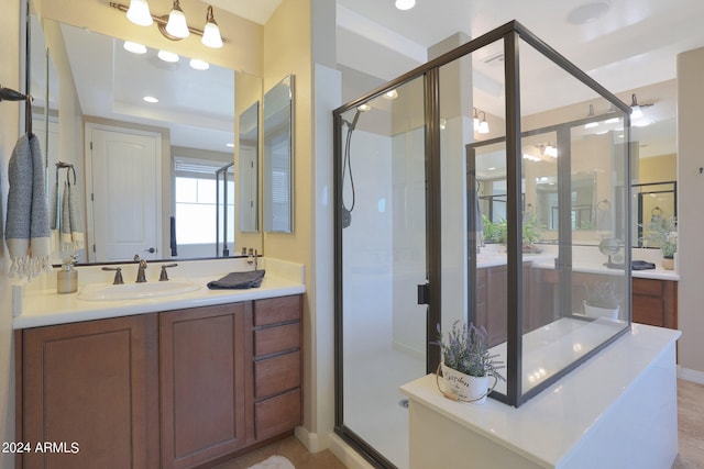 bathroom with a shower with shower door and vanity