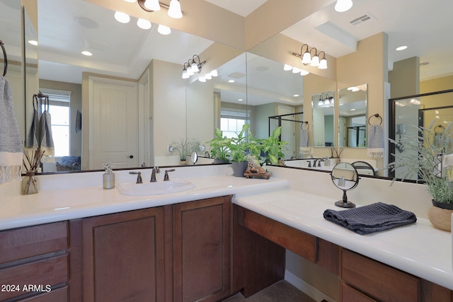 bathroom with a wealth of natural light, walk in shower, and vanity