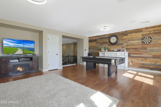 game room featuring wooden walls and dark hardwood / wood-style flooring