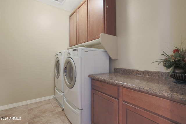 laundry area with independent washer and dryer and cabinets