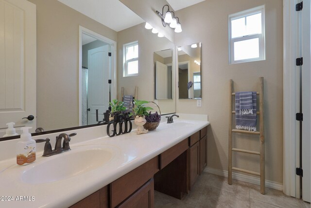 bathroom with tile patterned floors, vanity, and a wealth of natural light