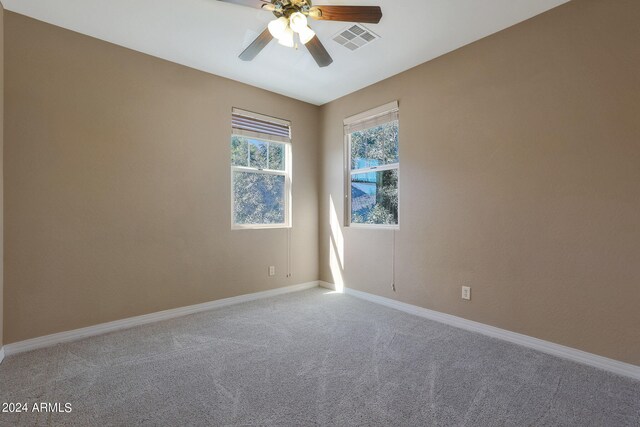 carpeted spare room with ceiling fan