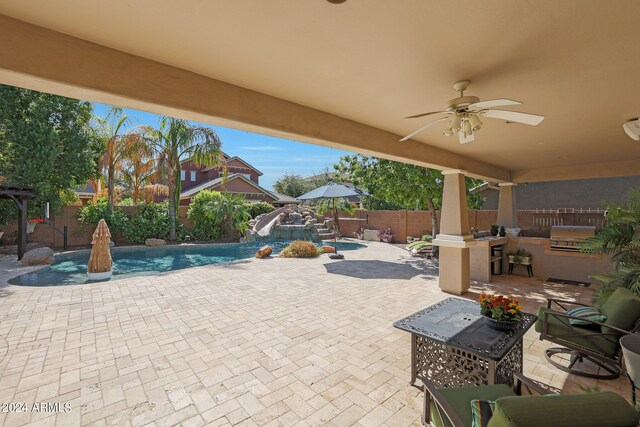 view of patio / terrace with ceiling fan, a fenced in pool, and pool water feature