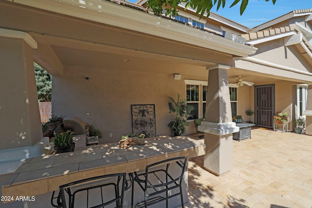 view of patio featuring exterior bar and ceiling fan