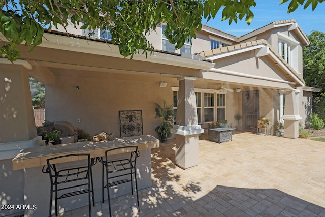 view of patio / terrace featuring ceiling fan and a bar