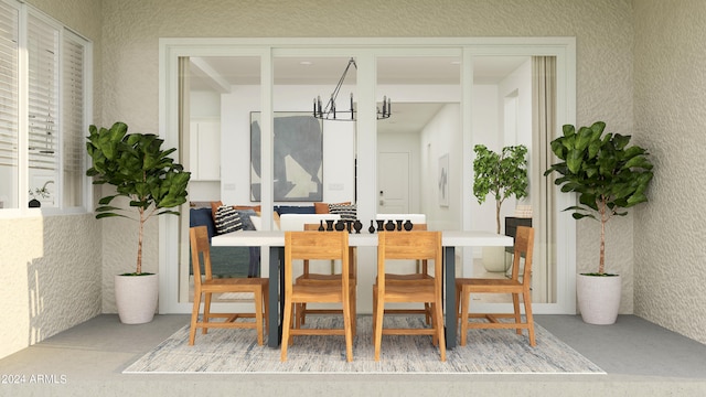 dining room with an inviting chandelier and concrete flooring