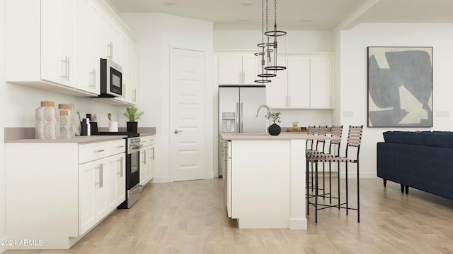 kitchen featuring pendant lighting, stainless steel range oven, white cabinetry, white refrigerator with ice dispenser, and an island with sink