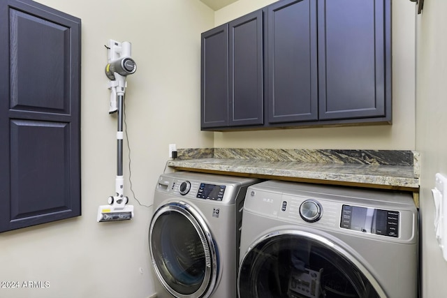 laundry area featuring washer and clothes dryer and cabinets